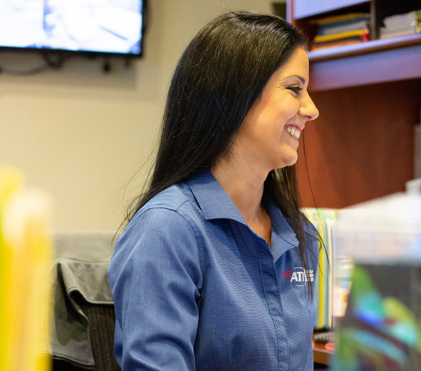 Smiling dark haired women in an ATI Restoration shirt