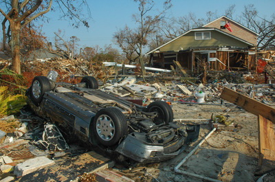 Upside-down car in the debris of a hurricane-damaged neighborhood.