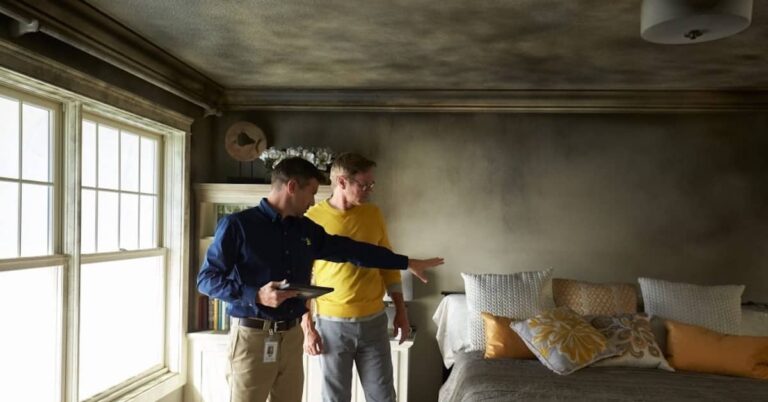 Homeowner and remediation professional assessing smoke damage after wildfires | ATI Restoration