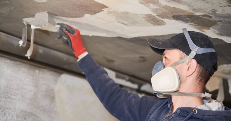 Restoration professional cleaning soot off a smoke-damaged ceiling | ATI Restoration